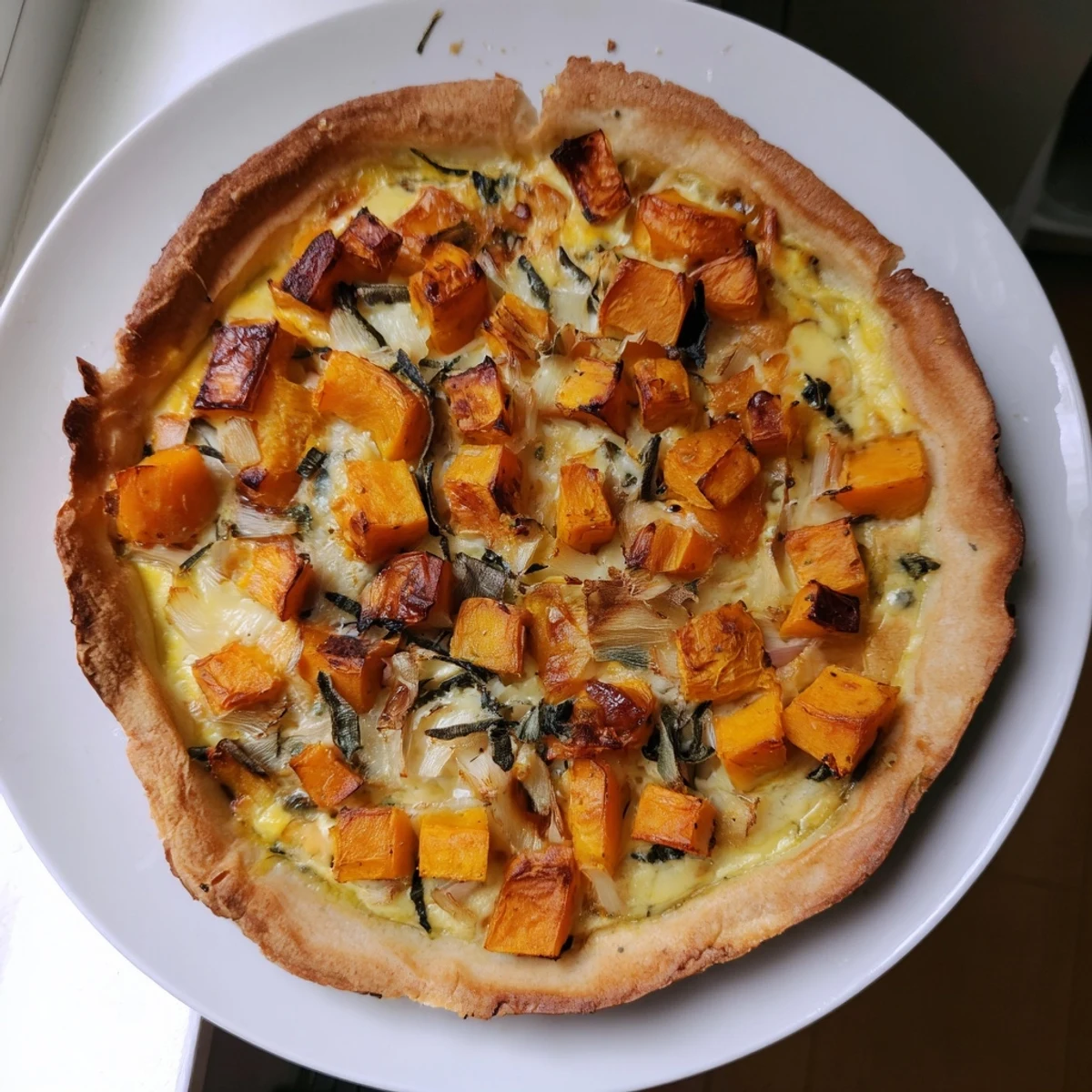 Slices of potato crust quiche with butternut squash, perfect for a cozy brunch meal.