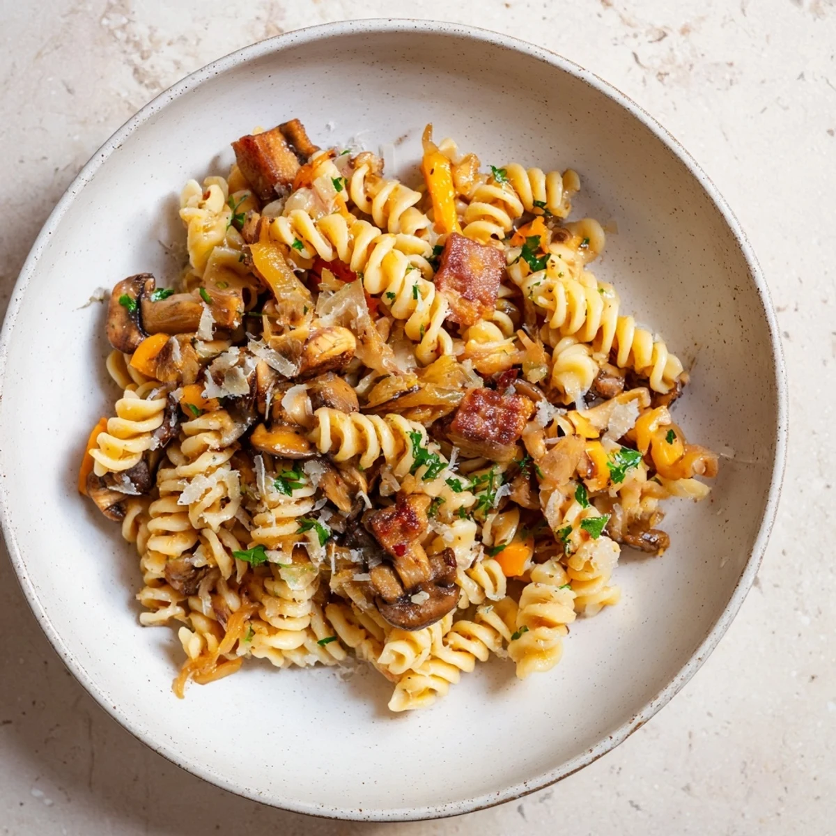 Golden, crispy bacon tops this fusilli with bacon, onions, and mushrooms, a savory Italian pasta dinner.