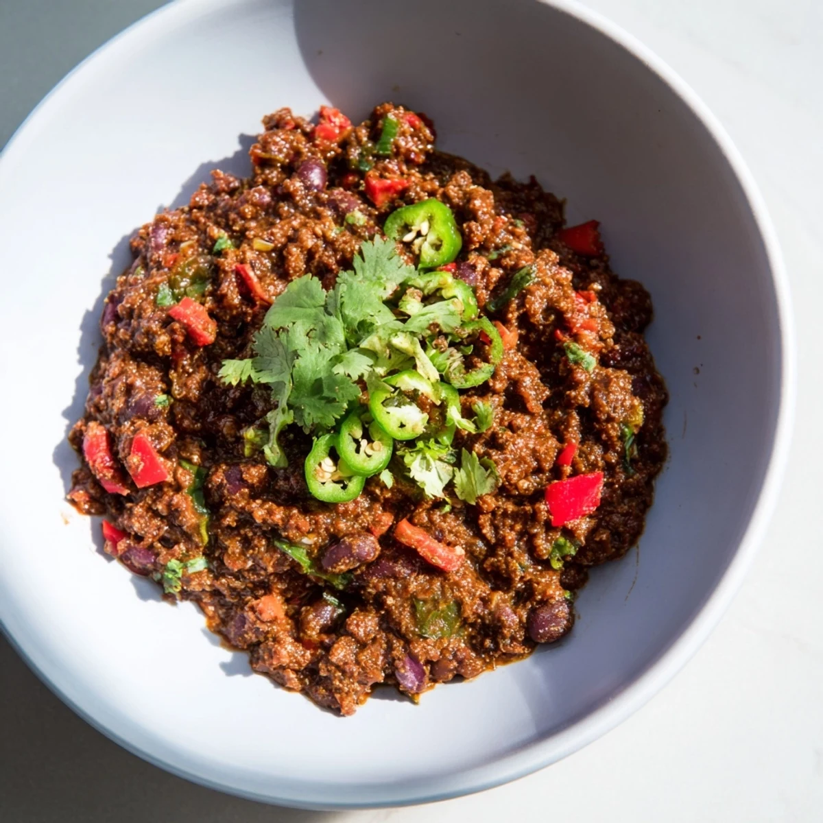 A close-up of a hearty bowl filled with flavorful Smoky Mole Chili, garnished with fresh cilantro.