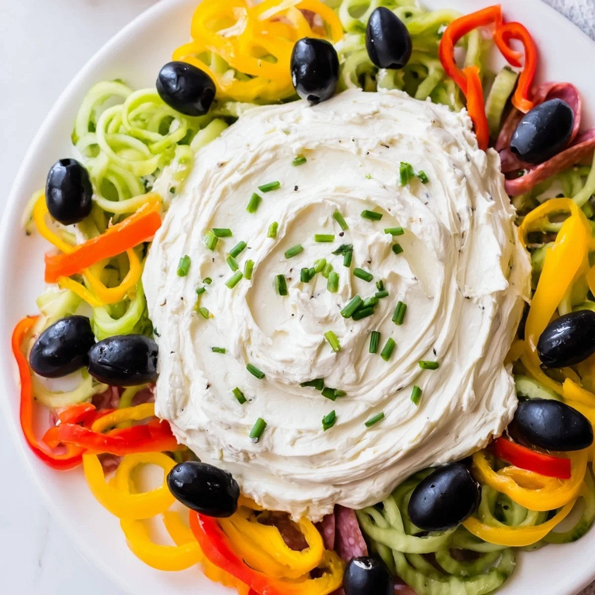 The Medusa Curls party platter: spiralized peppers and cured meats around a creamy dip head.