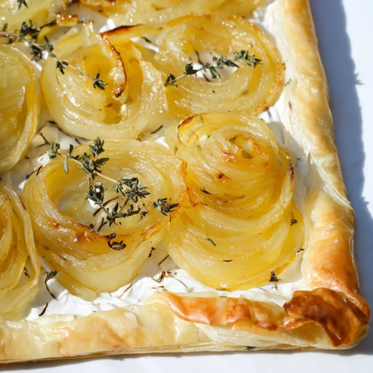 Golden, flaky Caramelized Onion Tart, generously topped with melted Gruyère, ready to serve.