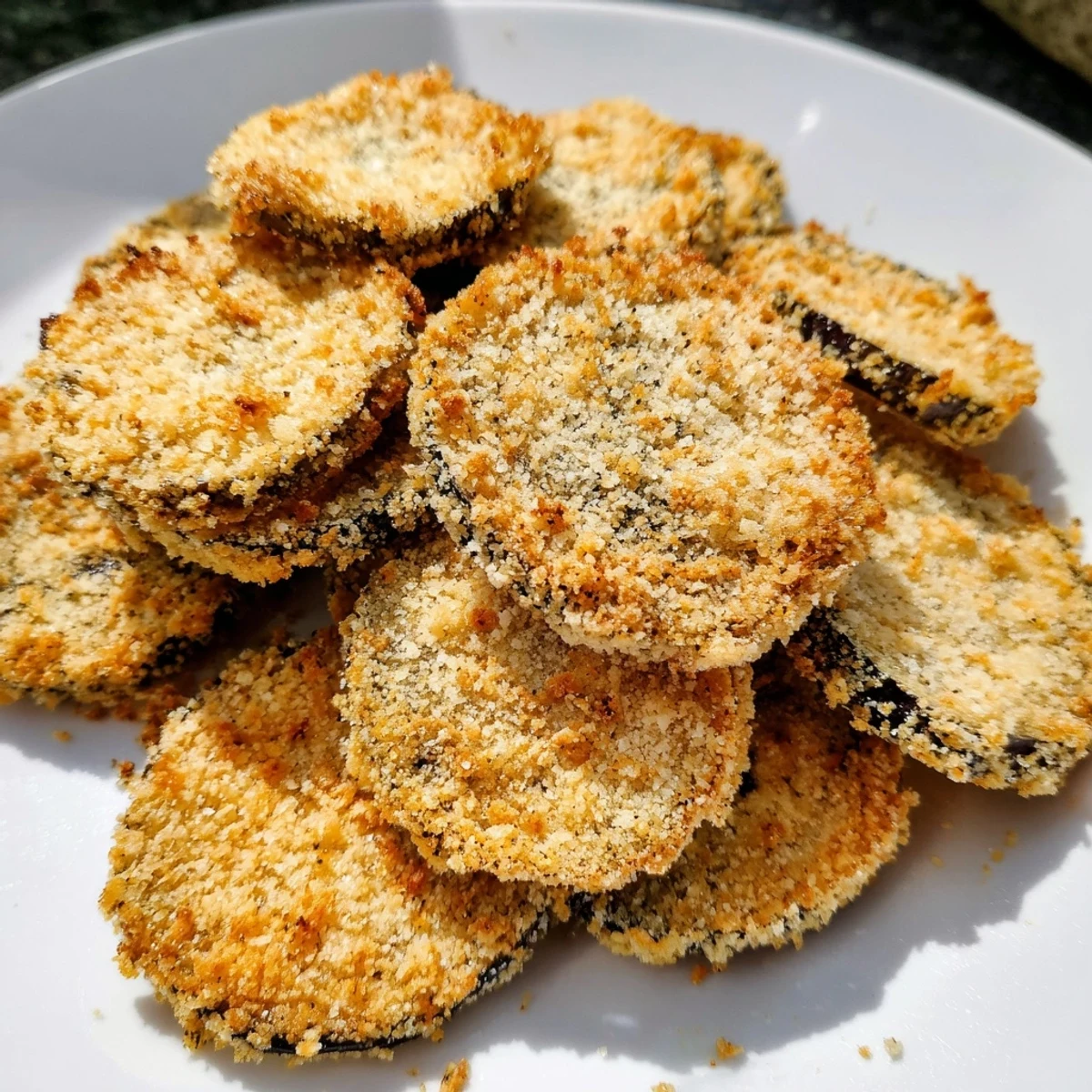 A close-up of delicious baked Eggplant Parmesan Chips, showing their perfect golden-brown crispiness.