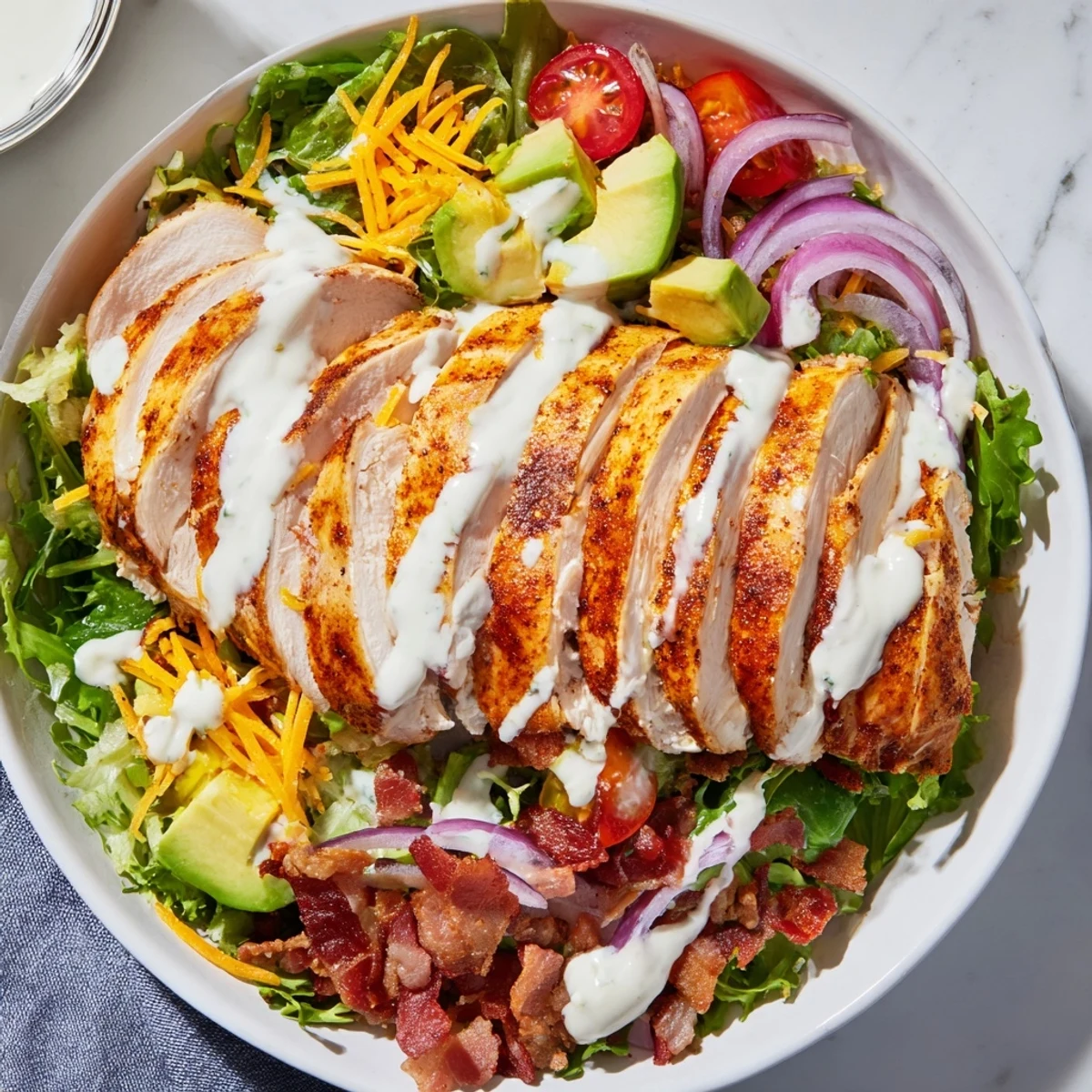 Hearty crispy bacon chicken salad with avocado and cheddar cheese, a delicious, easy main course.