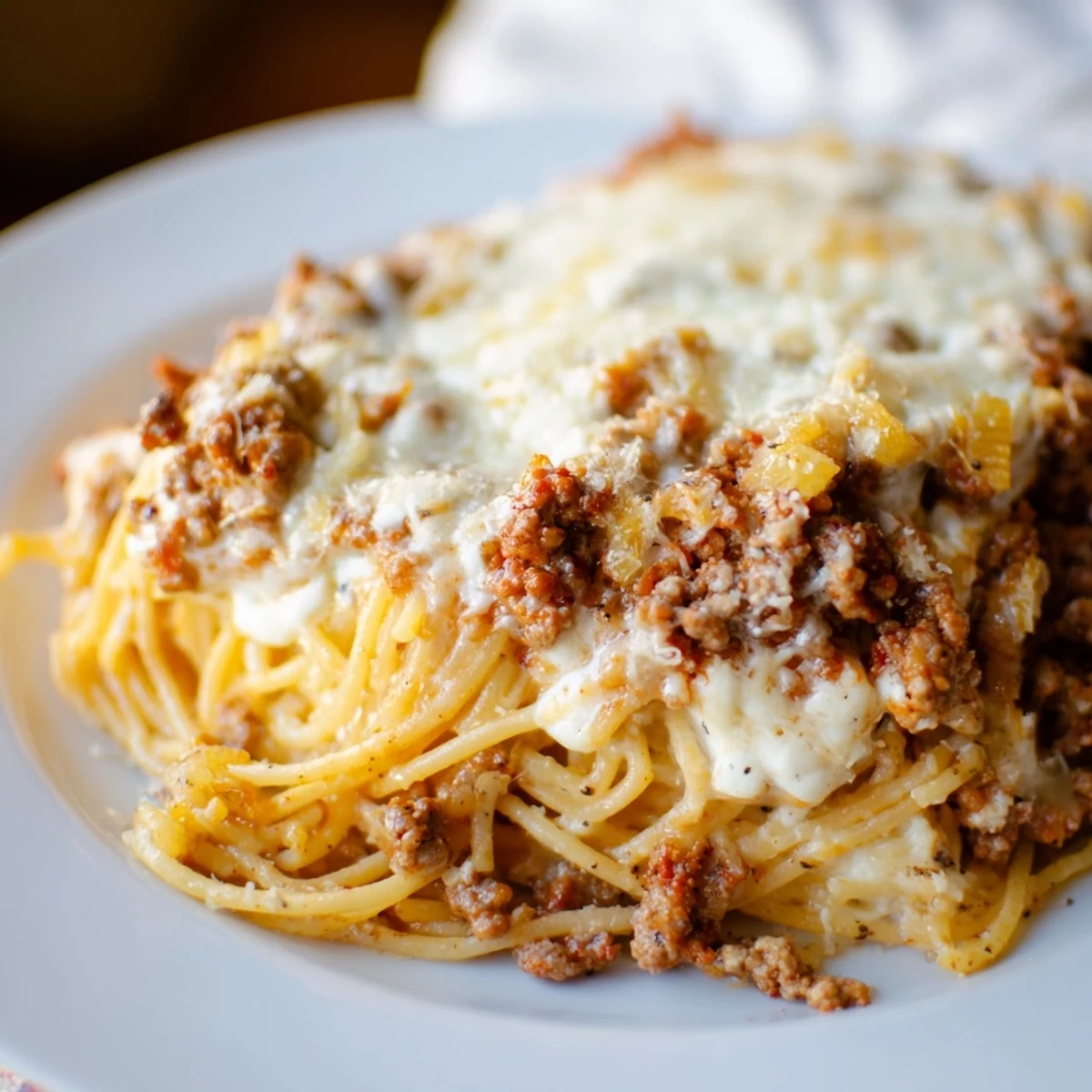 Golden, bubbly Million Dollar Spaghetti, a hearty baked pasta with layers of rich meat sauce and melted cheese.