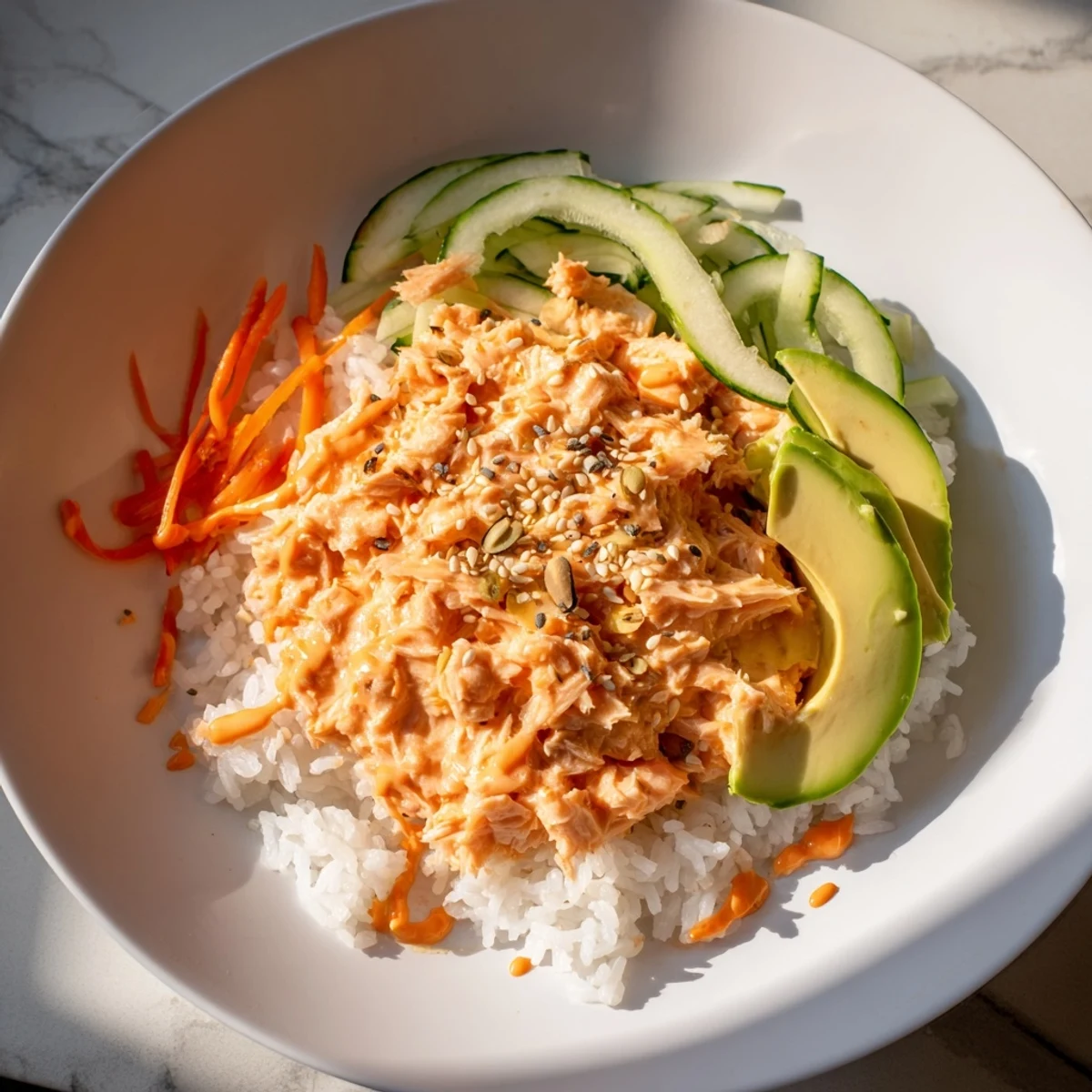 Flaky salmon glistens in a creamy sriracha sauce layered over a Spicy Canned Salmon Rice Bowl.