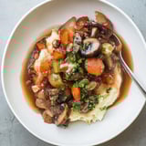 Creamy white root mash topped with rich, dark Rustic Mushroom and Shallot Stew, garnished parsley.