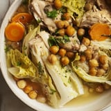 A close-up view of steaming Chicken Kale Soup with a garnish of herbs and crunchy chickpeas.
