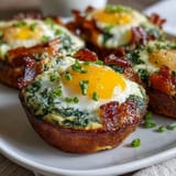 Green Eggs and Ham Breakfast Cups filled with savory ham, spinach-blended eggs, and melted cheddar in a muffin tin.
