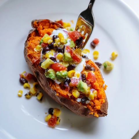 Steaming, fluffy Loaded Baked Sweet Potatoes, brimming with black beans, corn, and creamy avocado ready to eat.