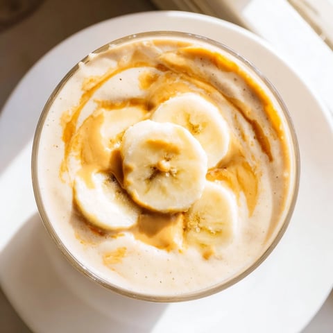 A thick, blended Peanut Butter Banana Smoothie, perfect for grabbing with a spoon this morning.