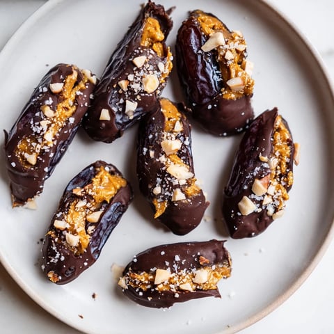 Decadent Chocolate Date Snickers, a sweet treat with dark chocolate coating glistening on the dates.