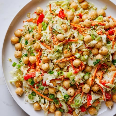 A bright bowl of Fiber-Forward Chickpea Salad, showcasing colorful veggies and creamy tahini dressing.