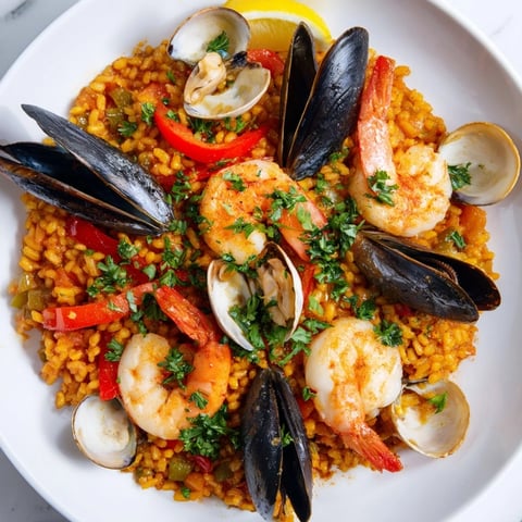 Fragrant Spanish Seafood Paella with colorful bell peppers, rice, and fresh parsley garnish.