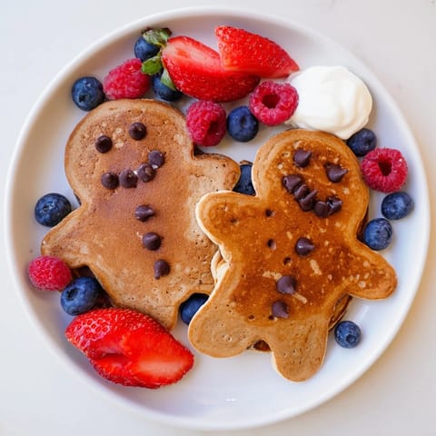 A beautifully arranged Gingerbread Boy Berry Board features golden gingerbread pancakes with vibrant, juicy berries.