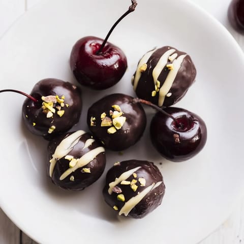 Artificially vibrant maraschino cherries peek from beneath layers of chocolate cherry dessert bites.