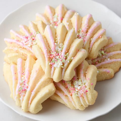 Buttery batch of freshly baked Spritz Cookies, sprinkled and arranged for a beautiful treat.
