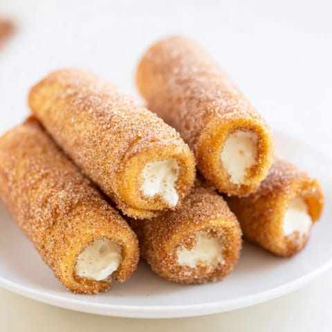 Picture the warm, crispy edges of these Easy French Toast Roll-Ups after being fried and sugared.