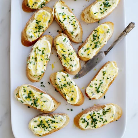 Crisp, toasted Vodka Butter Crostini slices topped with smooth butter, fresh herbs, and a hint of lemon, perfect for elegant appetizers.