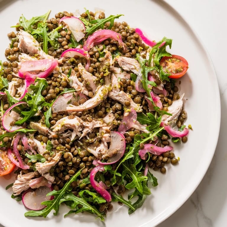 Tender lentils and shredded roasted chicken mingle with peppery arugula and cherry tomatoes in a hearty Lentil & Chicken Spring Salad.