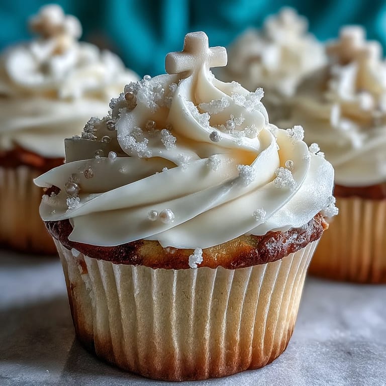 Elegant Communion cupcakes featuring tender vanilla cake, rich buttercream frosting, and handcrafted white fondant cross decorations for meaningful celebrations.