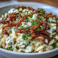 Orzo with Caramelized Onions and Goat Cheese, a creamy dish topped with fresh parsley.