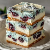 Creamy No-Bake Lemon Blueberry Cheesecake Bars with vibrant fruit swirls.